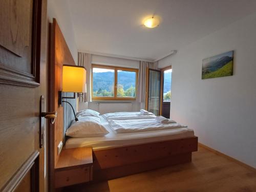 a bed in a room with a large window at Hochtenn Lodge in Zell am See - Steinbock Lodges in Zell am See