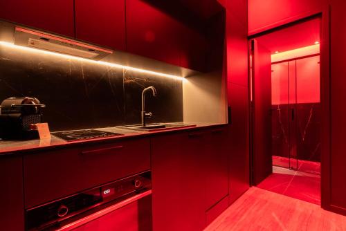 a red kitchen with a sink and a stove at Évasion intime : Love Room de luxe à Cannes in Cannes