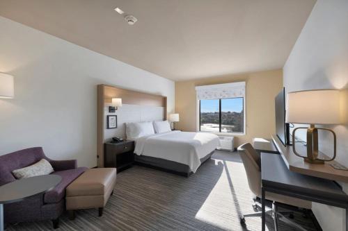 a large hotel room with a bed and a couch at Holiday Inn - Chicago - Tinley Park by IHG in Tinley Park