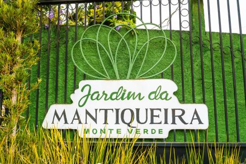 a sign in front of a fence with a plant at VELINN Pousada Jardim da Mantiqueira in Monte Verde