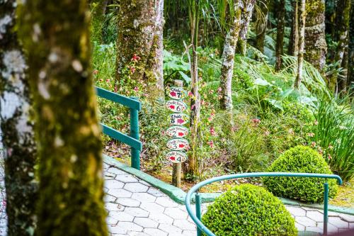 a sign in the middle of a garden at VELINN Pousada Jardim da Mantiqueira in Monte Verde