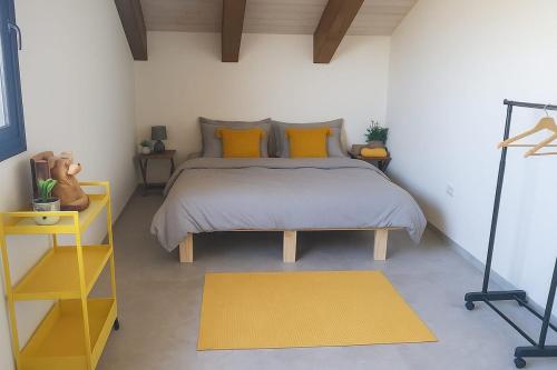 Un dormitorio con una cama grande con almohadas amarillas. en Peaceful Stay in the Golan, en Sha'al