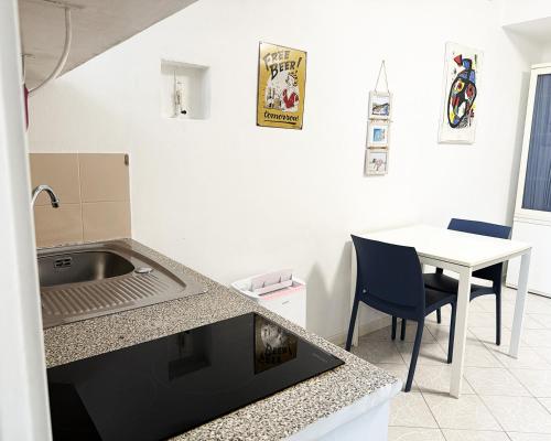 a kitchen with a sink and a table with a chair at Alture di Como-splendido appartamento in Como