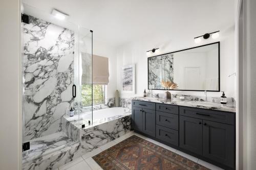 ein Badezimmer mit Badewanne, Waschbecken und Spiegel in der Unterkunft Newport Coast Bungalow in Newport Beach