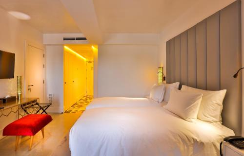a bedroom with a large white bed and a red chair at 2Ciels Boutique Hôtel in Marrakesh