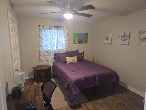 a bedroom with a purple bed and a ceiling fan at Yellow Mellow in Jackson