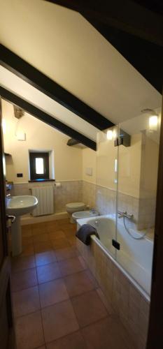 a bathroom with a bath tub and a sink at Villa Fonte in Ferrere