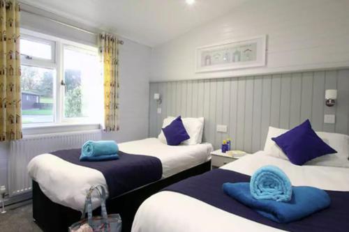 En eller flere senge i et værelse på Forest Edge 2 Bedroom Sublime Caravan with Hot Tub