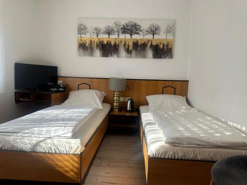 two beds in a room with a picture on the wall at Hotel Neue Traube in Fellbach