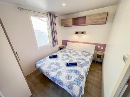 ein kleines Schlafzimmer mit einem Bett, auf dem zwei Schuhe liegen in der Unterkunft Happy Camp Mobile Homes in Il Pioppeto Camping&Residence in Marina di Montenero