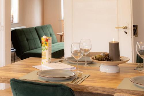 a wooden table with plates and wine glasses on it at 3 Zimmer Ferienwohnung Harter Brocken in Sankt Andreasberg