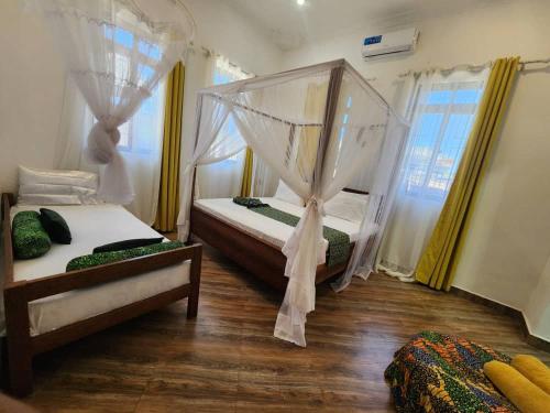 a bedroom with two beds and a window at Sisters House in Pingwe