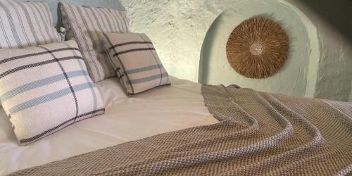a bedroom with a bed with pillows at Casa Cueva Solara, peace and nature in Cabo de Gata in Níjar