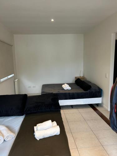 a room with a bed and towels on the floor at Lindisimo Apartamento en Country H Univ Austral in Pilar