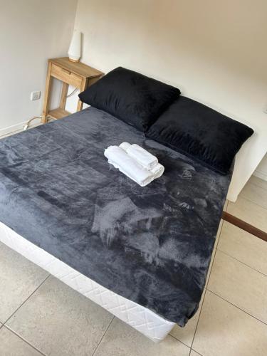 a bed with two towels on top of it at Lindisimo Apartamento en Country H Univ Austral in Pilar