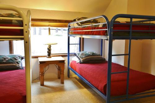 a bunk bed room with two bunk beds and a table at 8 Leisure in Sunriver