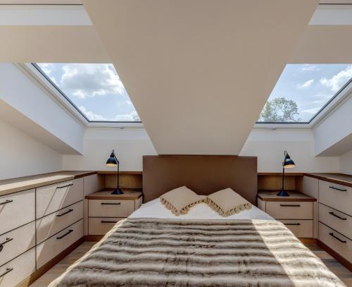 a attic bedroom with skylights and a bed at Tegernsee Luxury Chalet in Erlach