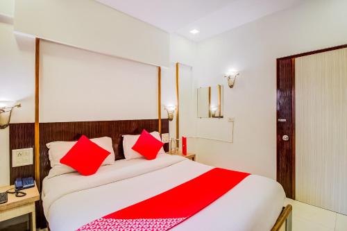 ein Schlafzimmer mit einem großen Bett mit roten Kissen in der Unterkunft Collection O Panchratna in Panvel