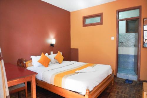 Un dormitorio con una cama grande con paredes naranjas. en Khangsar Home, en Katmandú