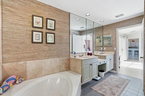 ein Badezimmer mit Badewanne und großem Spiegel in der Unterkunft SUPERB LAKESIDE VILLA WITH PRIVATE POOL NAPLES in Naples