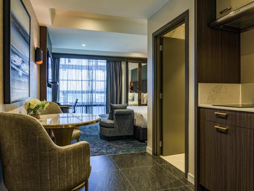 a hotel suite with a bedroom and a living room at The Sebel Wellington Lower Hutt in Lower Hutt