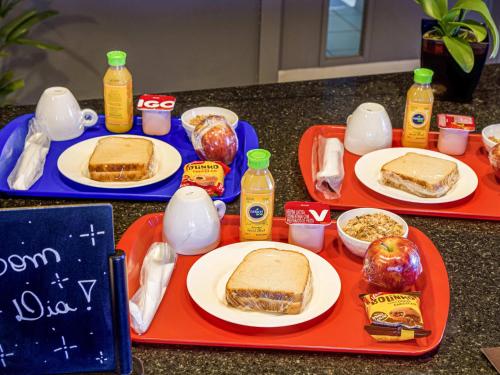 ein Tisch voller Teller mit Sandwiches und Essen in der Unterkunft ibis Ribeirao Preto Vila do Golf in Ribeirão Preto