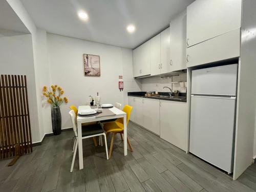 a kitchen with a table and chairs and a refrigerator at Almada Downtown 104 in Porto