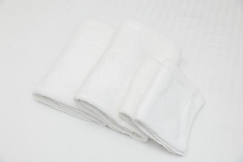 a white towel laying on a white background at Darin博多 in Fukuoka
