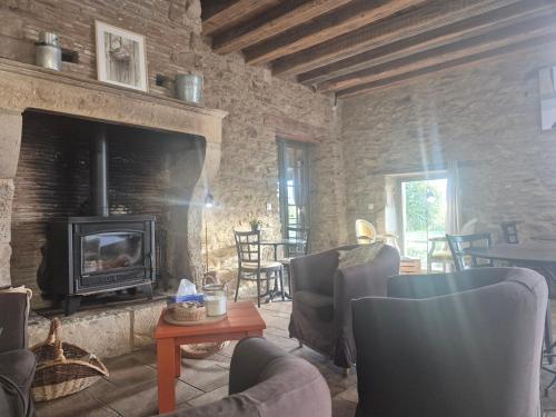 a living room with a stone fireplace and chairs at Domaine de la Tardoire in Oradour-sur-Vayres