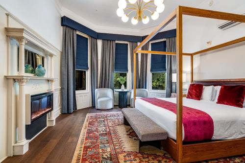 Un dormitorio con una cama con dosel y una chimenea. en White House Napa, en Napa