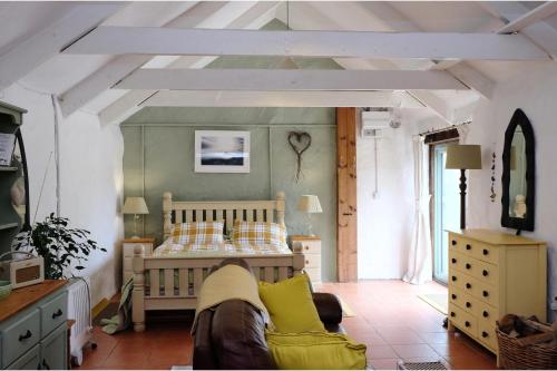 a bedroom with a bed and a couch in a room at Cottage Sleeps 2- Parking Wood Fire Garden Pets in Lizard