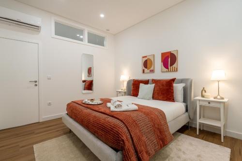 a white bedroom with a bed with a red blanket at Open-Plan Apartment in Downtown Porto by HostWise in Porto