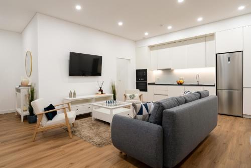 a living room with a couch and a kitchen at Open-Plan Apartment in Downtown Porto by HostWise in Porto