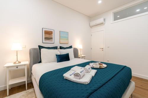 a bedroom with a large bed with towels on it at Open-Plan Apartment in Downtown Porto by HostWise in Porto