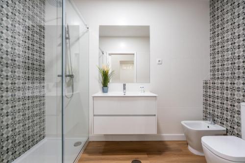 a bathroom with a sink and a toilet and a shower at Open-Plan Apartment in Downtown Porto by HostWise in Porto