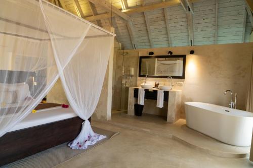 a bathroom with a bath tub and a sink at Jambiani Villas in Jambiani