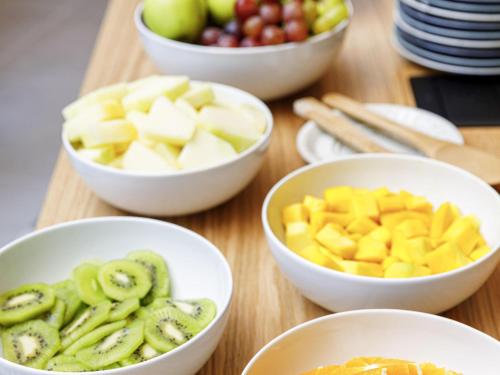 Mercure Porto Centro Aliados في بورتو: أربعة أطباق من الفاكهة على طاولة خشبية