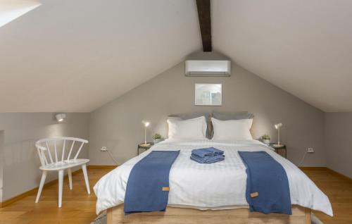 ein Schlafzimmer mit einem großen Bett und einem Stuhl in der Unterkunft Villa Castel Muschio by Villas Guide in Omišalj