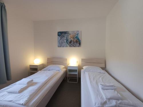 two beds in a room with two lights on at Profelt`s Apartments Uttendorf - Steinbock Lodges in Uttendorf