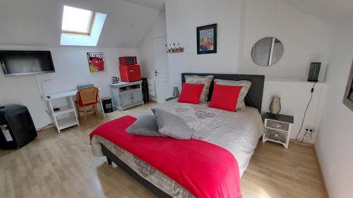 a bedroom with a large bed with red pillows at Halte détente chez Sylvie près A71 Bourges - chambres avec sauna, billard, salle ciné in Civray