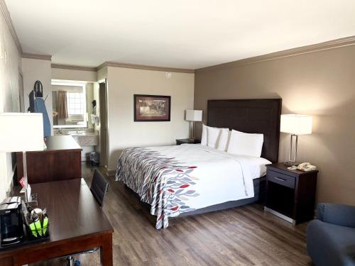a hotel room with a bed and a desk at Red Roof Inn Forrest City in Forrest City