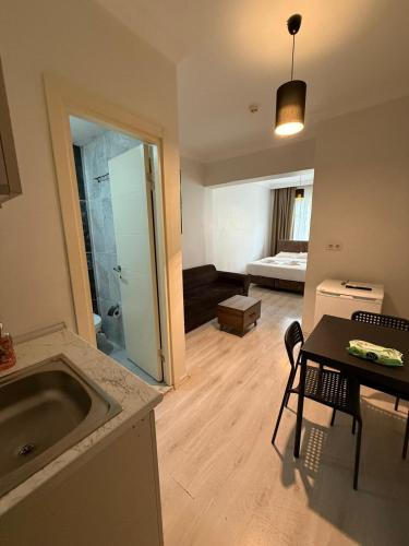 eine Küche und ein Wohnzimmer mit einem Waschbecken und einem Tisch in der Unterkunft Şişli Suites - Room26 in Istanbul