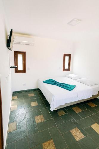 1 dormitorio blanco con 1 cama en una habitación en Pousada Mazé, en Itanhaém