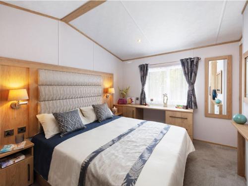 a bedroom with a large bed and a sink at Wilksworth Caravan Park in Wimborne Minster