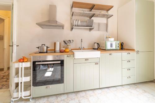 a kitchen with white cabinets and a sink at La Maison Castello in Abbiategrasso