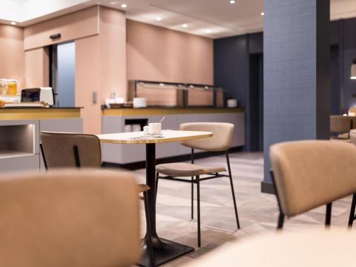 um restaurante com mesa e cadeiras e um balcão em Mercure Mainz City Center em Mainz