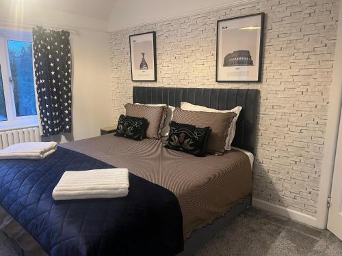 a bedroom with a bed with a brick wall at 4 BRD House, with Double Parking in Earley