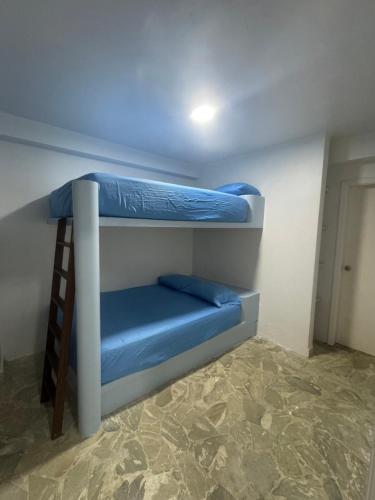 2 Etagenbetten in einem Zimmer mit blauer Bettwäsche in der Unterkunft Apartamento vacacional Tucacas in Tucacas