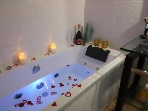 a white bath tub with candles in a bathroom at Villa Saint Barth in Gujan-Mestras