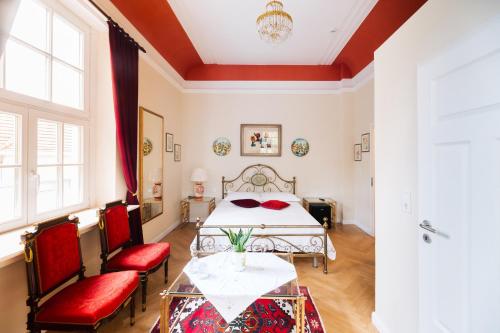 a bedroom with a bed and two red chairs at Nove Verde in Bremen